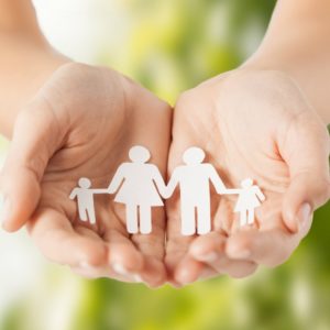 eco, bio, nature, love, harmony concept - woman cupped hands showing paper man family